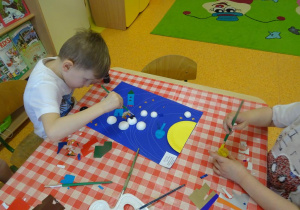 Dzieci malują farbami kulki styropianowe.